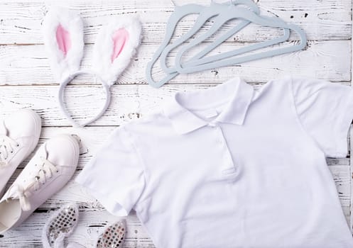 Spring holidays, Happpy Easter. white polo shirt and bunny ears for mockup design on white wooden background