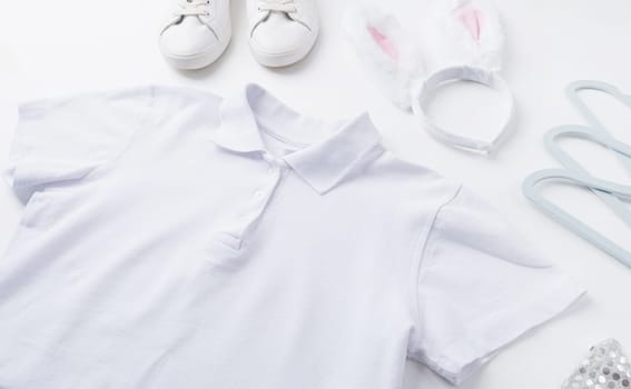 Spring holidays, Happpy Easter. white polo shirt and bunny ears for mockup design on white wooden background