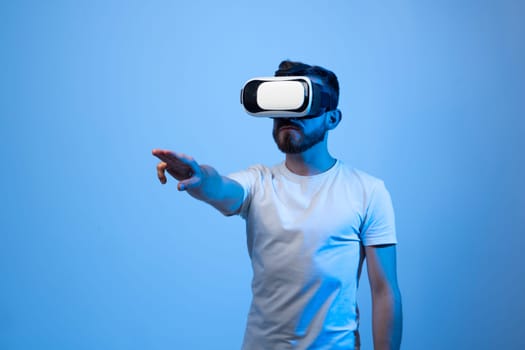 Bearded man in VR glasses trying to touch something. Future, technology and people concept