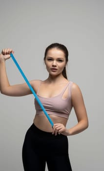 Happy slim brunette woman in sport wear with measuring tape on white background. Positive weight loss diet results. Healthy lifestyles concept