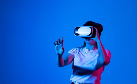 Woman in white shirt wearing VR glassess, VR set equipment for exploring a metaverse. Concept of metaverse, virtual reality, future, technology and internet