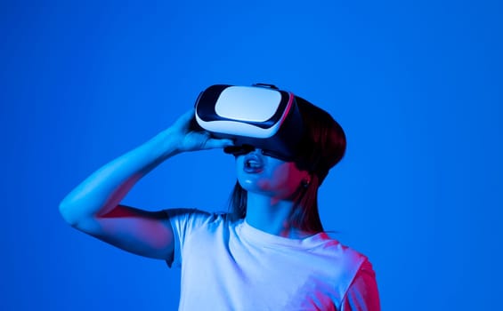 Young woman in virtual reality VR glasses playing a video games