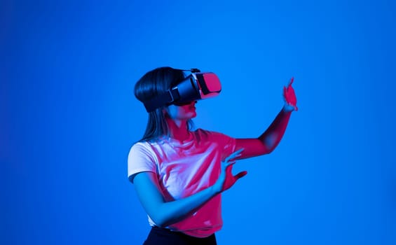 Woman wearing a VR headset and interacting with virtual reality. Simulation, future technology, AR and metaverse concept
