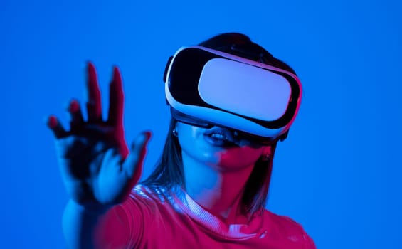 Brunette woman wearing VR virtual reality headset touching air during the VR on Metaverse experience. Technology, Video Game and Metaverse Concept