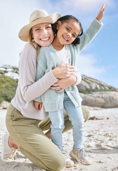 Love, mother and girl on beach, bonding and relax for holiday vacation and outdoor together. Mama, daughter and happy kid with smile, embrace and hug on seaside sand, in summer and adventure travel