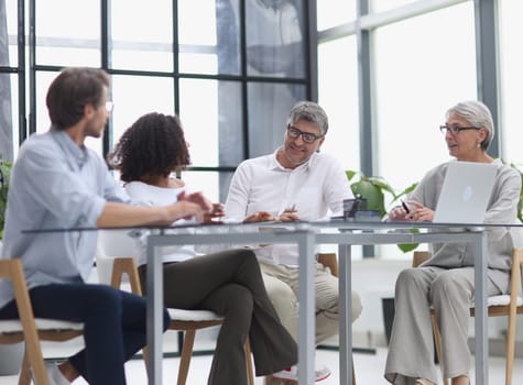 Serious team of professionals, business people negotiating in modern boardroom, discuss project