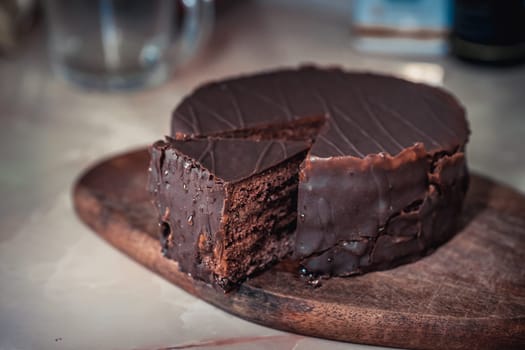Round chocolate cake with triangular slice cut off. High quality photo