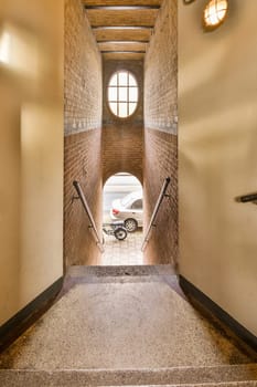 a motorcycle parked in an old brick building, taken from the inside and out with its front wheel leaning on the wall