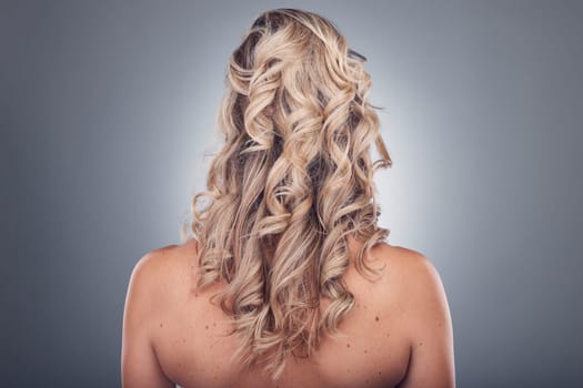 Hair care, beauty and woman with curly hairstyle texture after salon treatment in a studio. Gray background, isolated and model with hairdresser balayage, dye and growth from haircut and keratin.