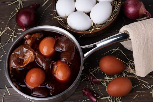 Coloring chicken eggs for Easter with onion peel. Easter, Sunday. Healthy food. Dark key, rustic. Selective focus.