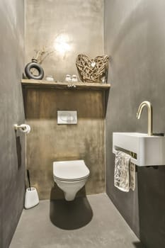 a bathroom with a toilet, sink and mirror on the wall next to it is an artistic sculpture that looks like a bird's