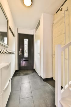 a modern bathroom with black tile flooring and white walls, there is a mirror on the wall above the sink