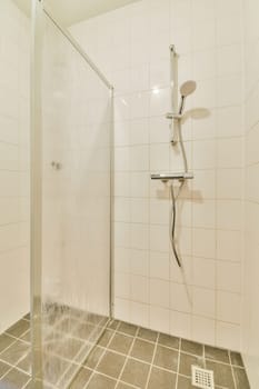 a shower stall with water coming from the shower head and hand held up to it's side, in a white tiled bathroom