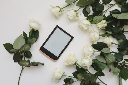 roses blossom with phone. device mockup with white flowers