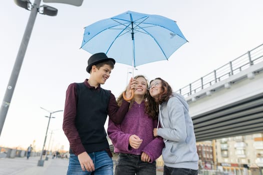 Teens boy and two girls talking and having fun outdoor, lifestyle of teenagers in the city