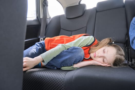 9 year old girl sleeping in car, child lying in the back seat of vehicle.