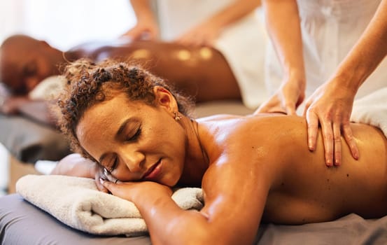 Hands, massage and relax with a couple in a spa, lying on a table for wellness or luxury at a resort. Skin, bed and therapy with a man and woman in a beauty center for zen on holiday or vacation.