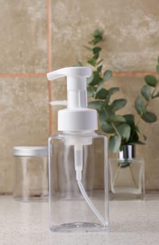 Transparent plastic container with a dispenser on the table. Bottle for liquid soap, shampoo