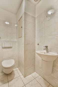 a bathroom that is very clean and white with marble tiles on the walls, floor, and toilet in it