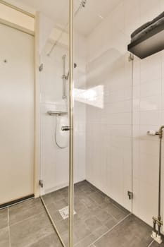 a shower room with tile flooring and white tiles on the walls there is a mirror in the corner to the wall