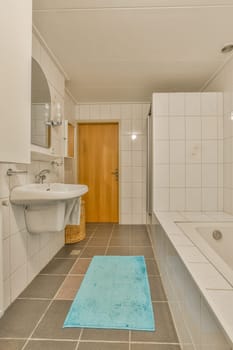 a bathroom with a blue rug on the floor and a white bathtub in the corner, next to a sink