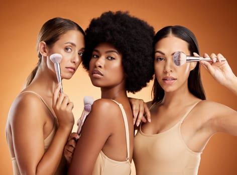 Makeup, beauty and women with brush for cosmetics against a brown mockup studio background. Portrait of young model group with cosmetic facial foundation and a luxury product for skin wellness.