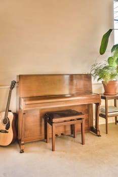 a living room with a piano, chair and potted plant in the corner on the wall is painted white