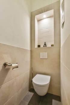 a toilet in the corner of a bathroom with tile on the walls, and a wall mounted mirror above it