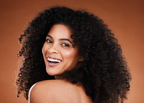 Black woman, beauty and haircare with portrait for curly hair and hairstyle on a brown studio background. Afro, african american person and style or healthy texture and conditioner treatment.