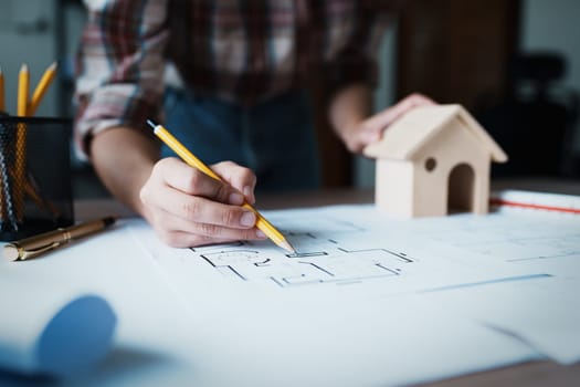 Engineers are designing house structures and architectural using blueprints, rulers, pencils, dividers and building models to work.