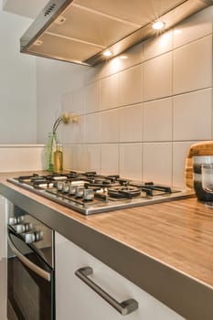 a kitchen with white tiles and wood counter tops on the stovetop, which has been used as an appliance for cooking