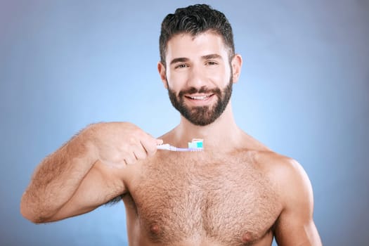 Teeth, toothbrush and portrait of man in studio for dental wellness, healthy smile and mouth care. Happy face, male model and oral cleaning for fresh breath, gums and dentistry on blue background.