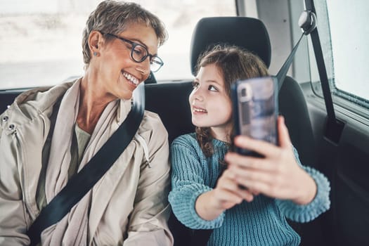 Travel, phone and selfie with girl and grandmother in car for road trip adventure on vacation for holiday, transportation and social media. Happy, smile and vacation with family for internet post.