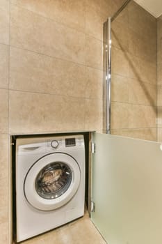 a laundry room with a washing machine in the corner and a mirror on the wall next to the washer