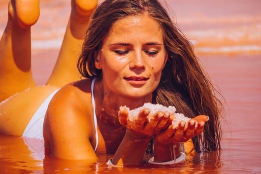 Salt mining. Salty pink lake with crystals of salt. Extremely salty pink lake, colored by microalgae with crystalline salt depositions