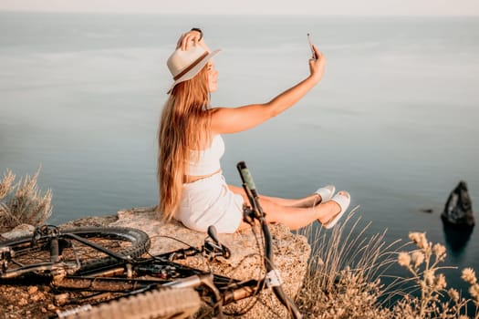 Woman travel sea. Young Happy woman in a long red dress posing on a beach near the sea on background of volcanic rocks, like in Iceland, sharing travel adventure journey