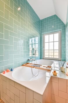 a bathroom with blue and white tiles on the walls, along with a large bathtub in the tub is next to the window