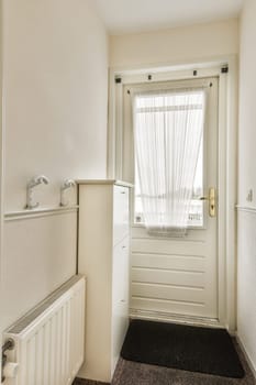 a door and window in a small room with white trim on the walls, carpeted floor and radiaing