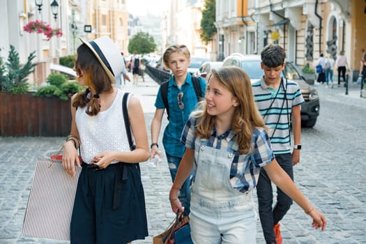 Group of teenagers with shopping bags on city street