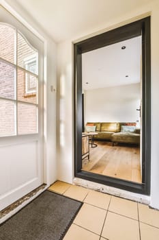 a living room with a couch in the corner and an open door that leads to another room on the other side