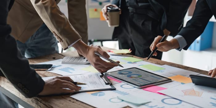 Business People Meeting using laptop computer, calculator, stock market chart paper for analysis planning to improve quality next month. Conference Discussion Corporate Concept.