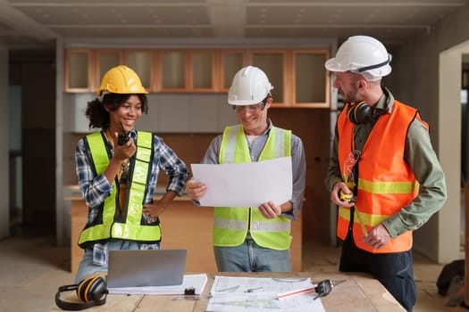 Architect team working with blueprints for architectural plan, engineer sketching a construction project, green energy concept.