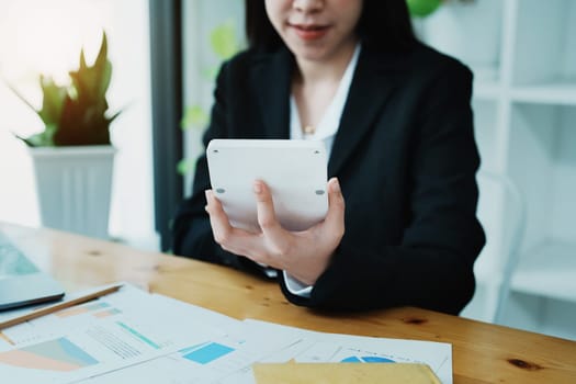 financial, Planning, Marketing and Accounting, portrait of Asian employee checking financial statements using documents and calculators at work..