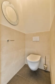 a toilet in the corner of a bathroom with a round mirror on the wall above it and an open door