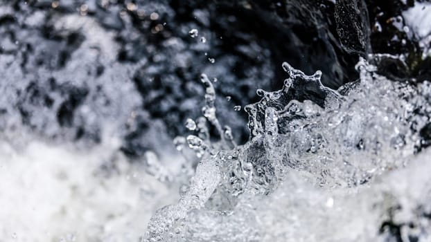 Close focus on body of splashing water of fast flowing stream in river.