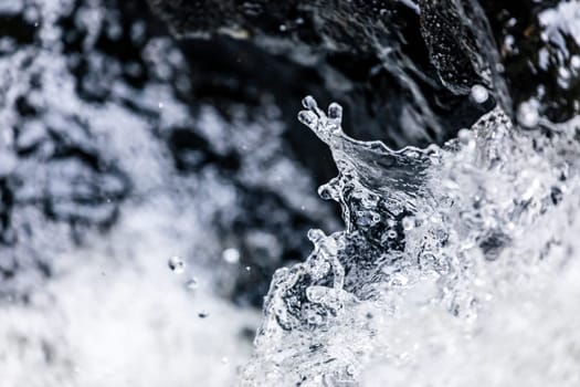 Close focus on body of splashing water of fast flowing stream in river.