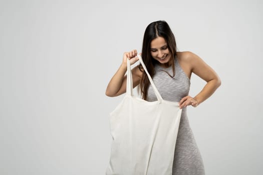 Zero waste concept with copy space. Woman holding cotton shopper with vegetables, products. Eco friendly mesh shopper. Zero waste, plastic free concept