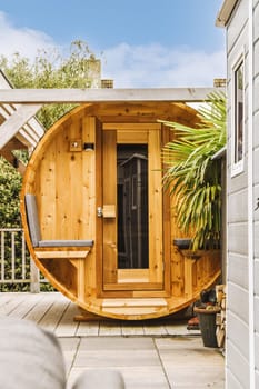 an outside area with a hot tub and pots on the ground in front of a wooden barrel like structure