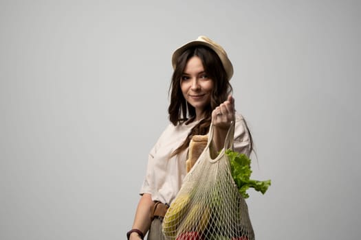 Attractive beautiful happy woman carries cotton bag full of organic vegetables and fruits. Zero waste concept, sustainable lifestyle, eco friendly concept, no plastic