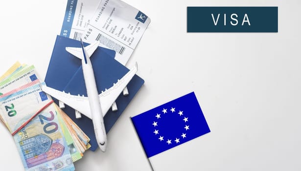 Flag of European Union with passport and toy airplane on wooden background. Flight travel concept.